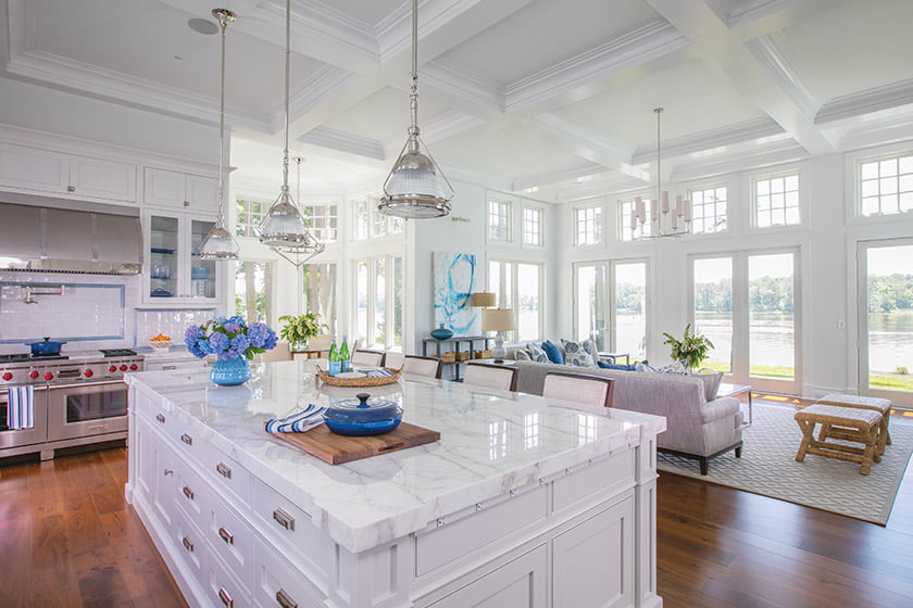 The kitchen/family room features a Calacatta Gold marble island countertop and Visual Comfort pendants.