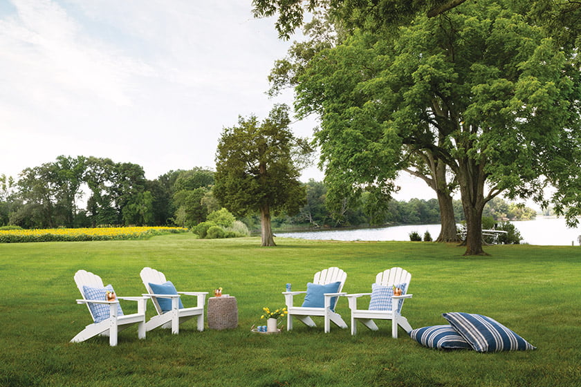 The house overlooks picturesque Hunting Creek, with a lawn bordered by a field of sunflowers.