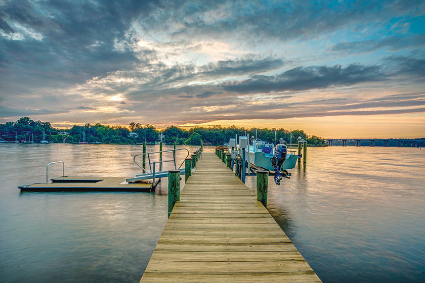 A dock with a boat lift and floating pier are part of the view.