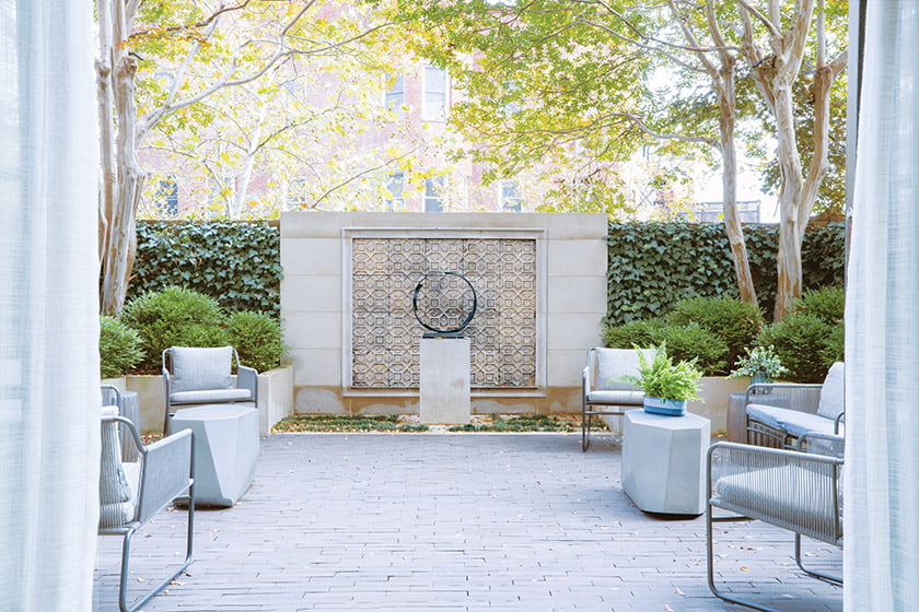 In the rear courtyard, a wall of vintage Japanese tile creates a backdrop for a bronze Bruno Romeda sculpture.