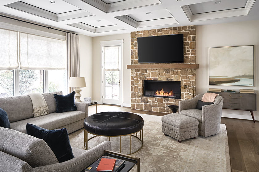 The family room’s fireplace wall juxtaposes natural stone with sleek, linear styling.