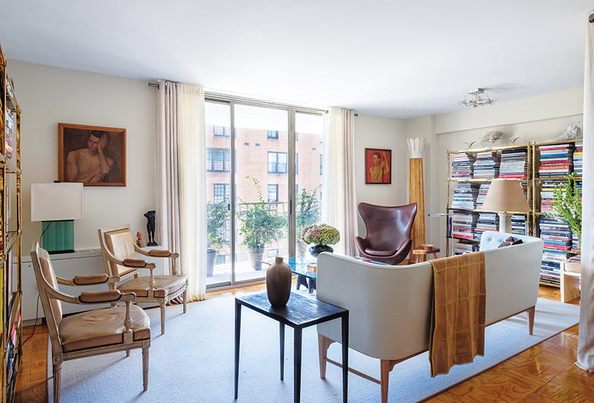 Living area with sliding balcony doors framed in Kravet drapery is anchored by rug from Bloomsburg