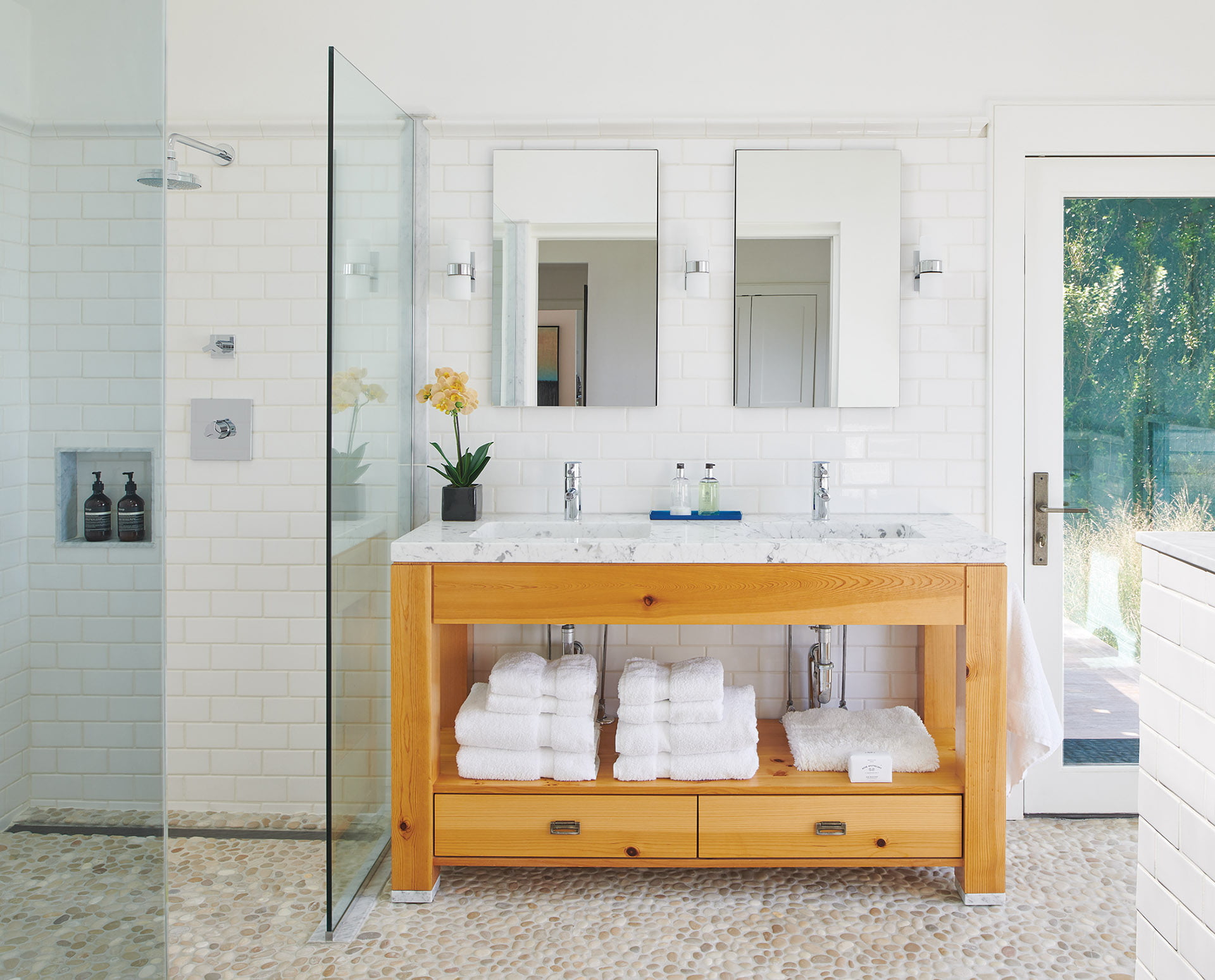 Owners’ bathroom, marble-topped, knotty-pine vanity and pebbled flooring from Ann Sacks.