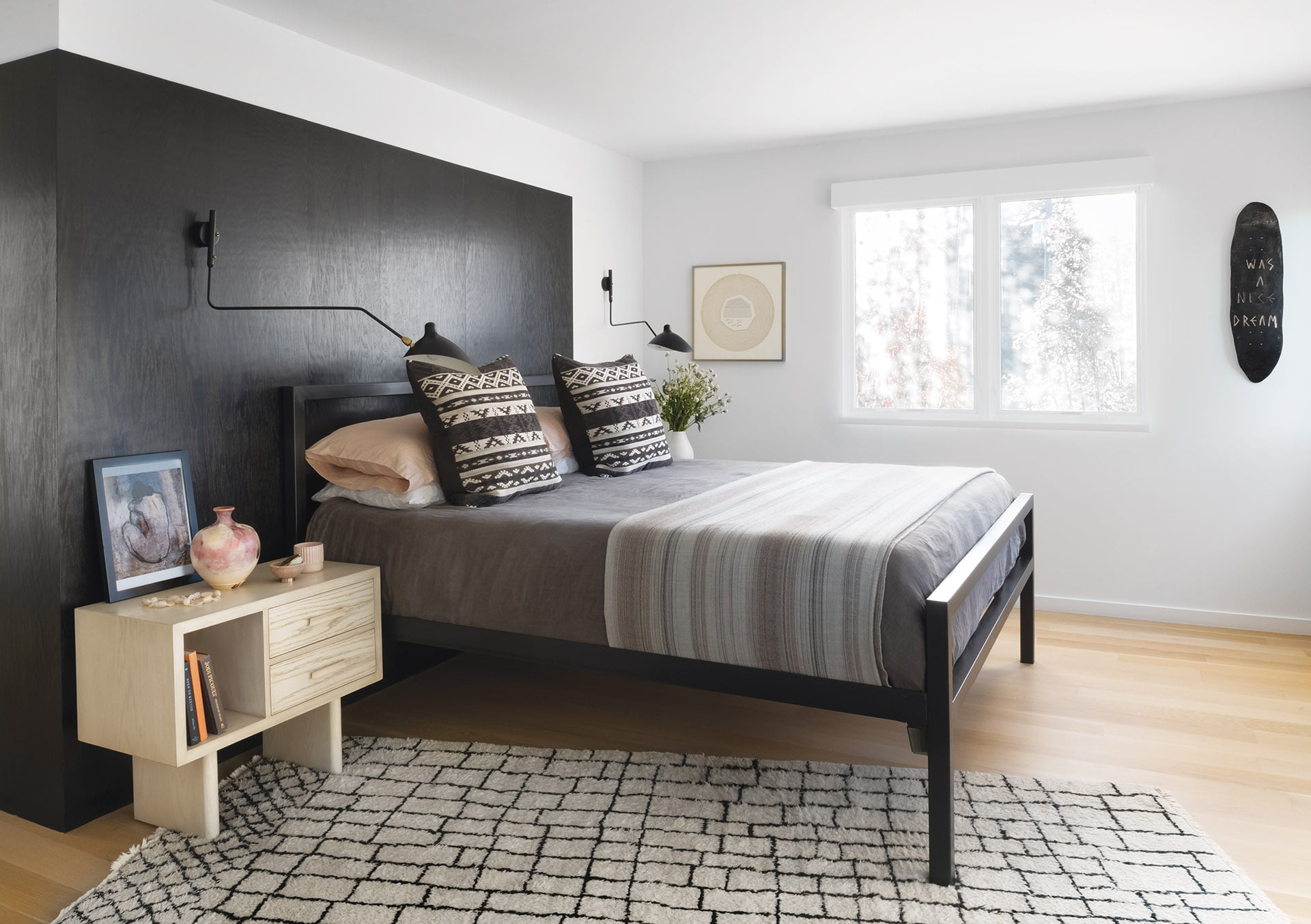 Black-stained birch panels the wall behind a Room & Board bed and Lawson-Fenning nightstand in the owners’ suite.
