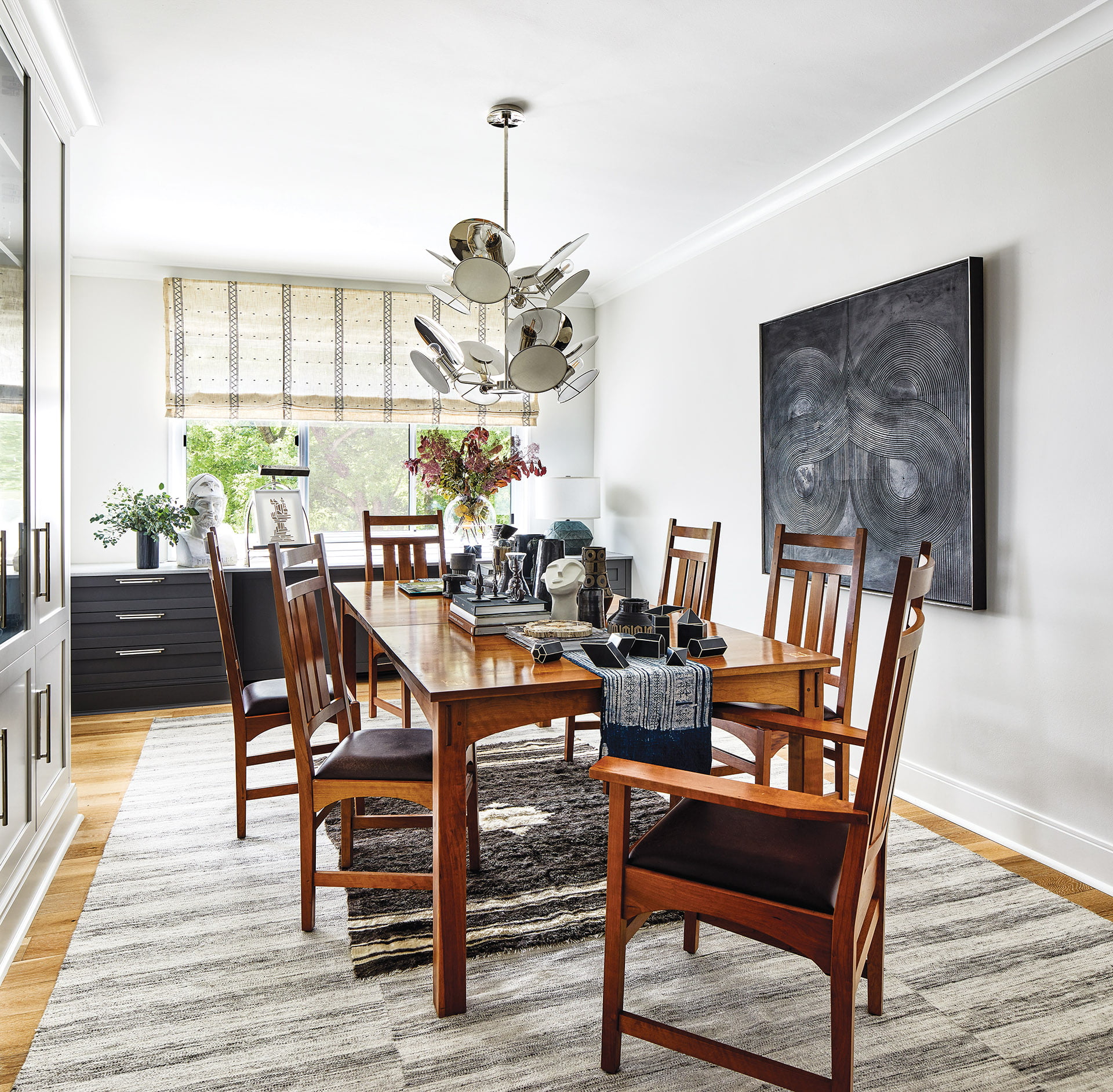 Craftsman table and chairs in dining room, modern Visual Comfort chandelier and sculptural painting by DC artist Stephen Benedicto.