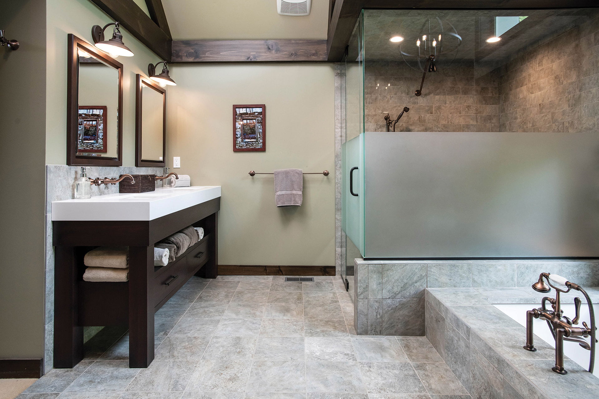 Dark-stained vanity and glass shower enclosure in luxurious tub