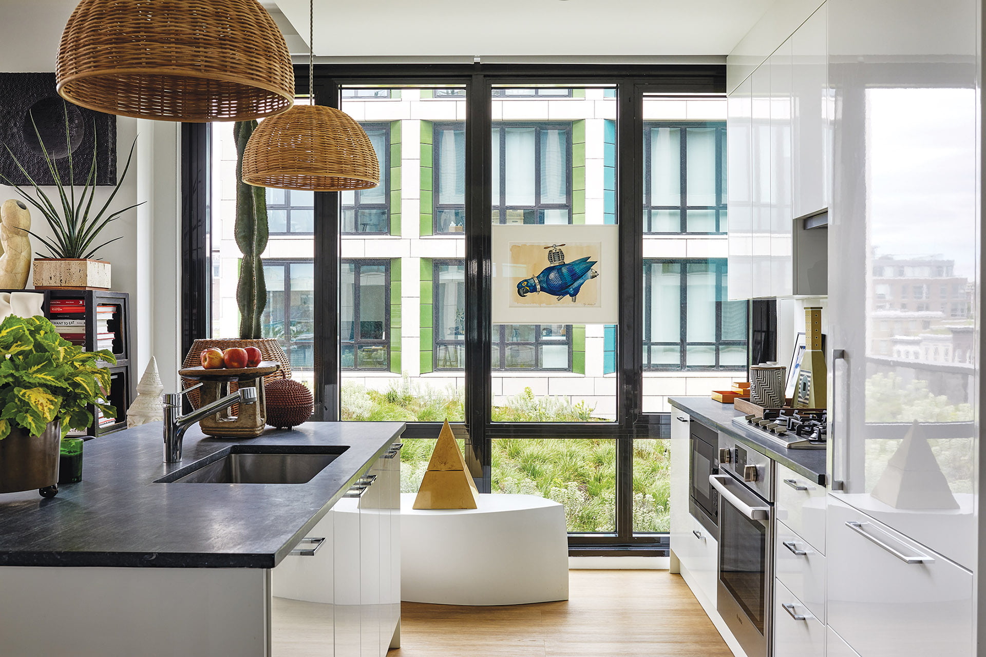 In the kitchen, a bench by Frank Gehry for Kartell holds a pyramidal ice bucket by Aldo Tura.