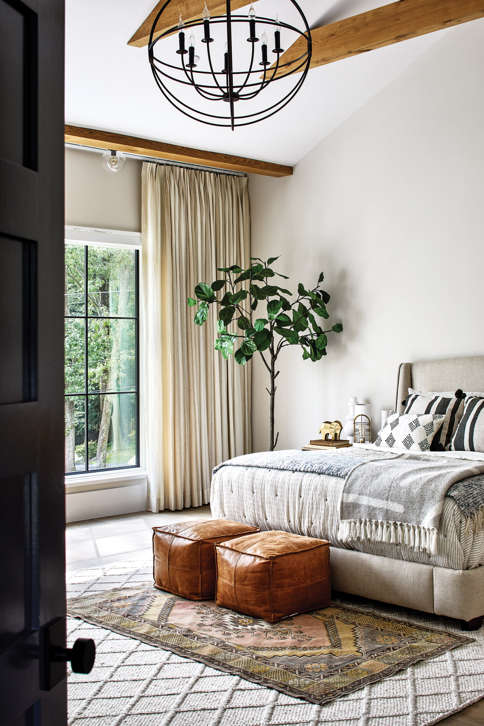 Off-white walls, warm oak accents and custom bedding in owners bedroom