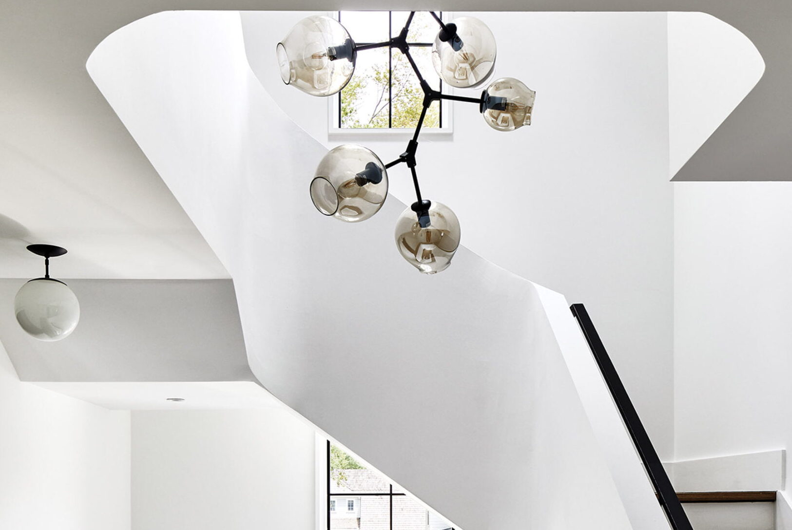 Sculptural staircase with chandelier by France & Son