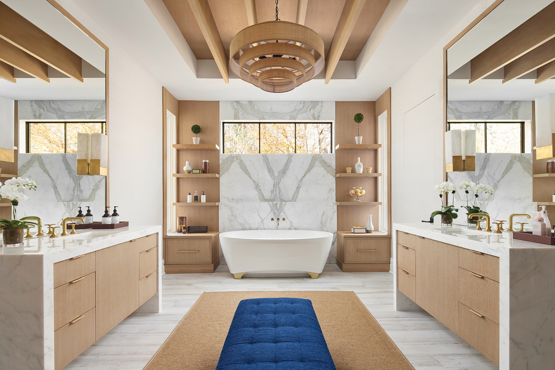Lobkovich open shelving with a tub and Currey & Company chandelier for a stylish bathroom design | Home and Design