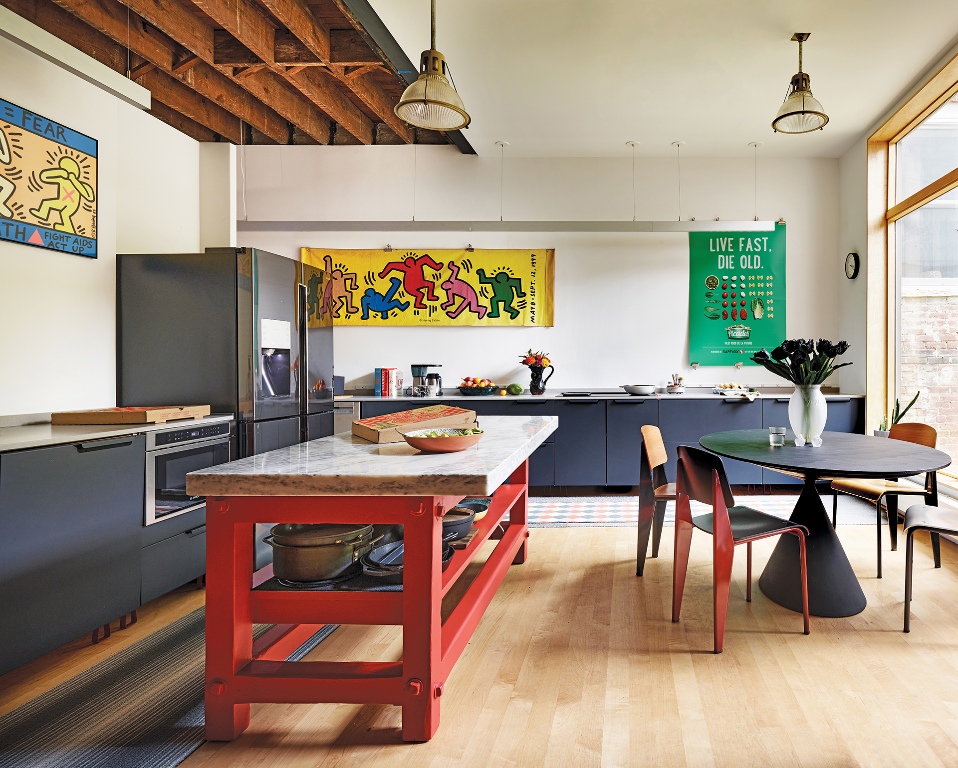 Red worktable with marble, Mark Krusin table, and Prouve chairs in the kitchen | Home and Design Magazine