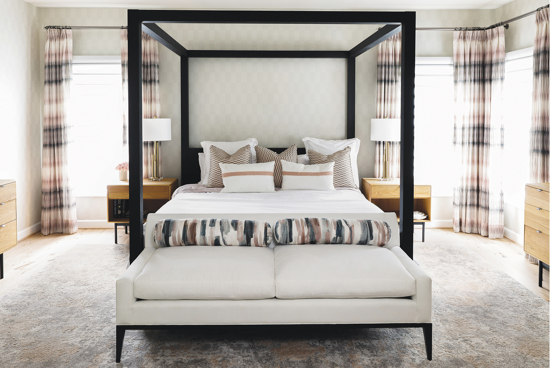 Elegant primary bedroom designed by Samantha Friedman with brown and cream hues, tartan plaid drapes, and an abstract rug | Home and Design