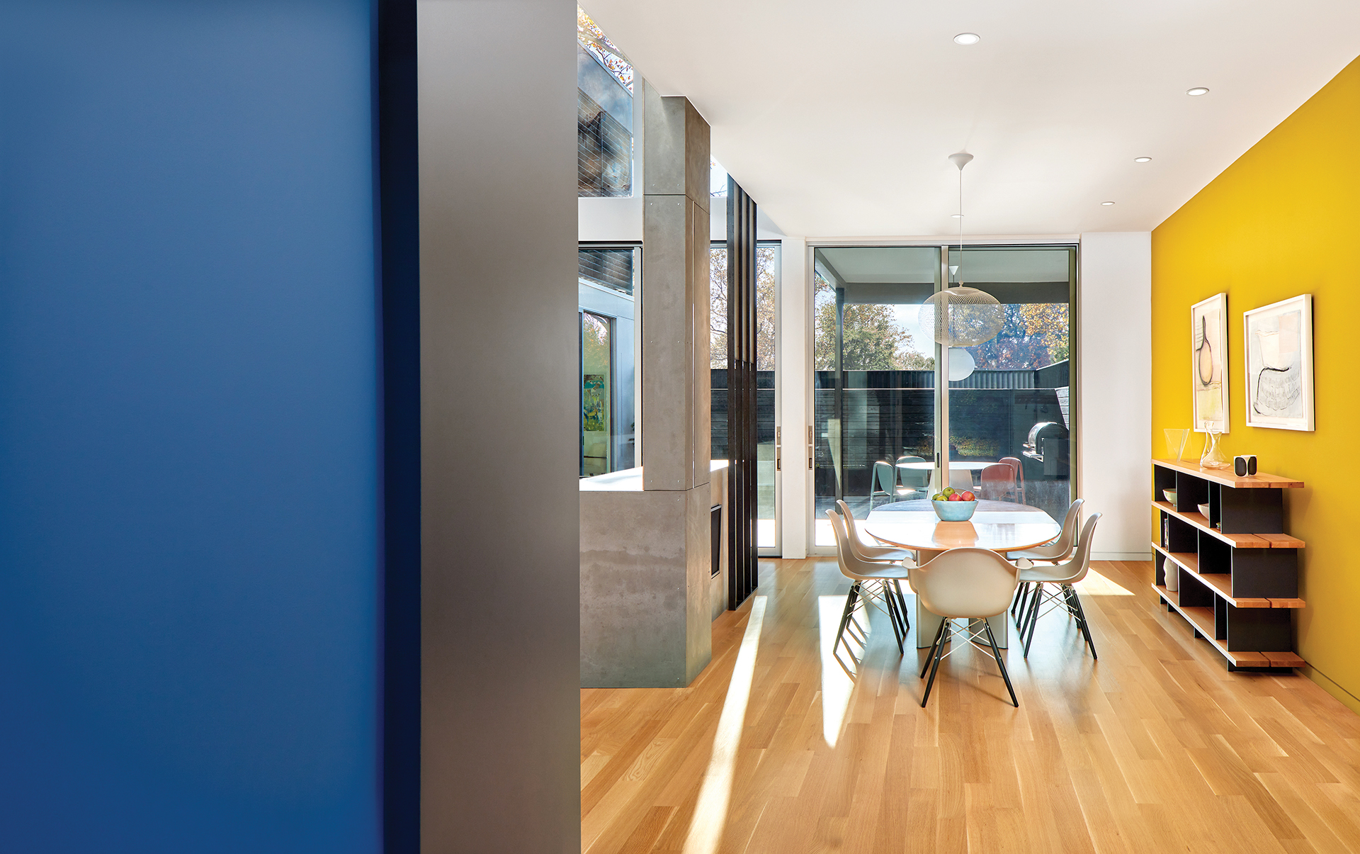 Dining area with Moooi pendant, sleek table, Eames chairs; main courtyard view | Home and design Magazine