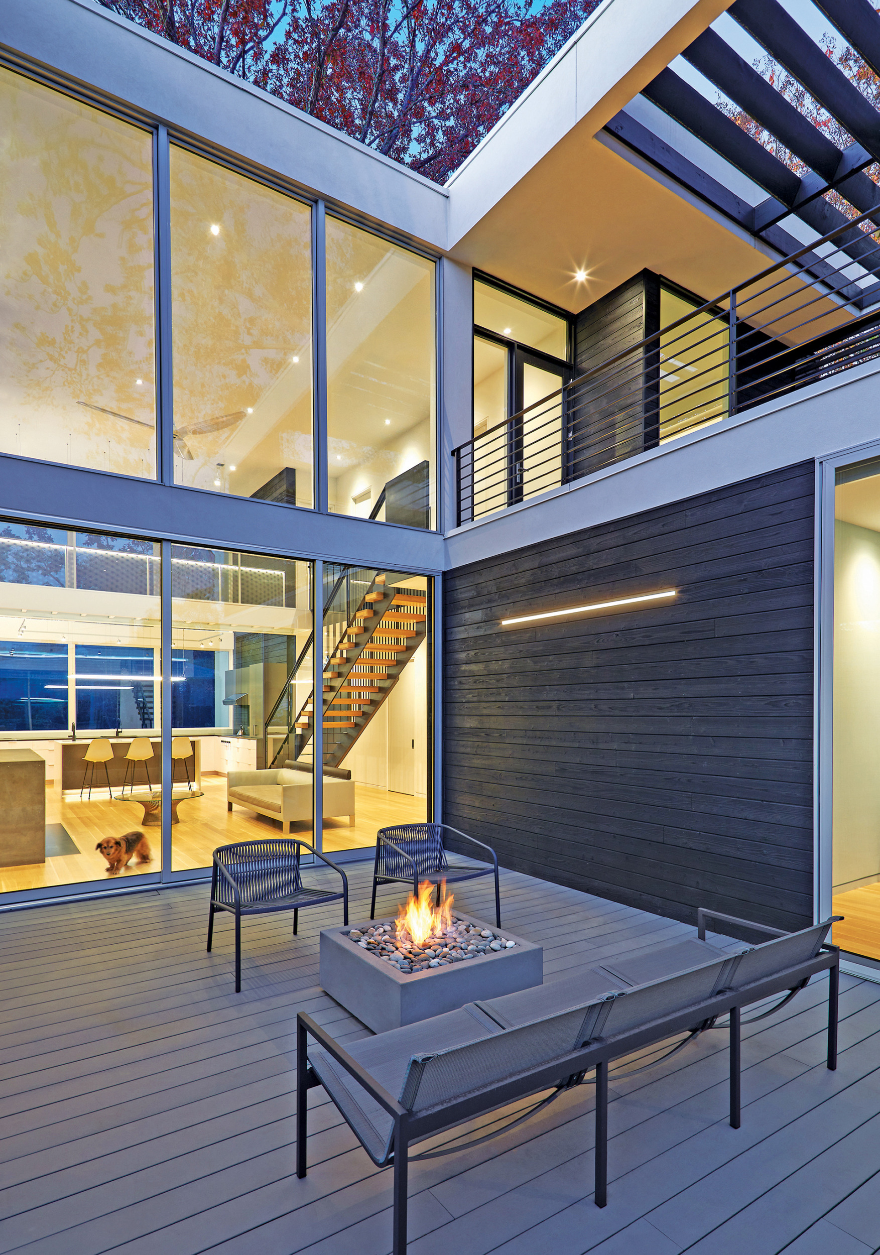 Sliding doors extend living area to courtyard; Blu Dot seating, Paloform fire feature, shou sugi ban siding with GlowbackLED strips. | Home and Design Magazine
