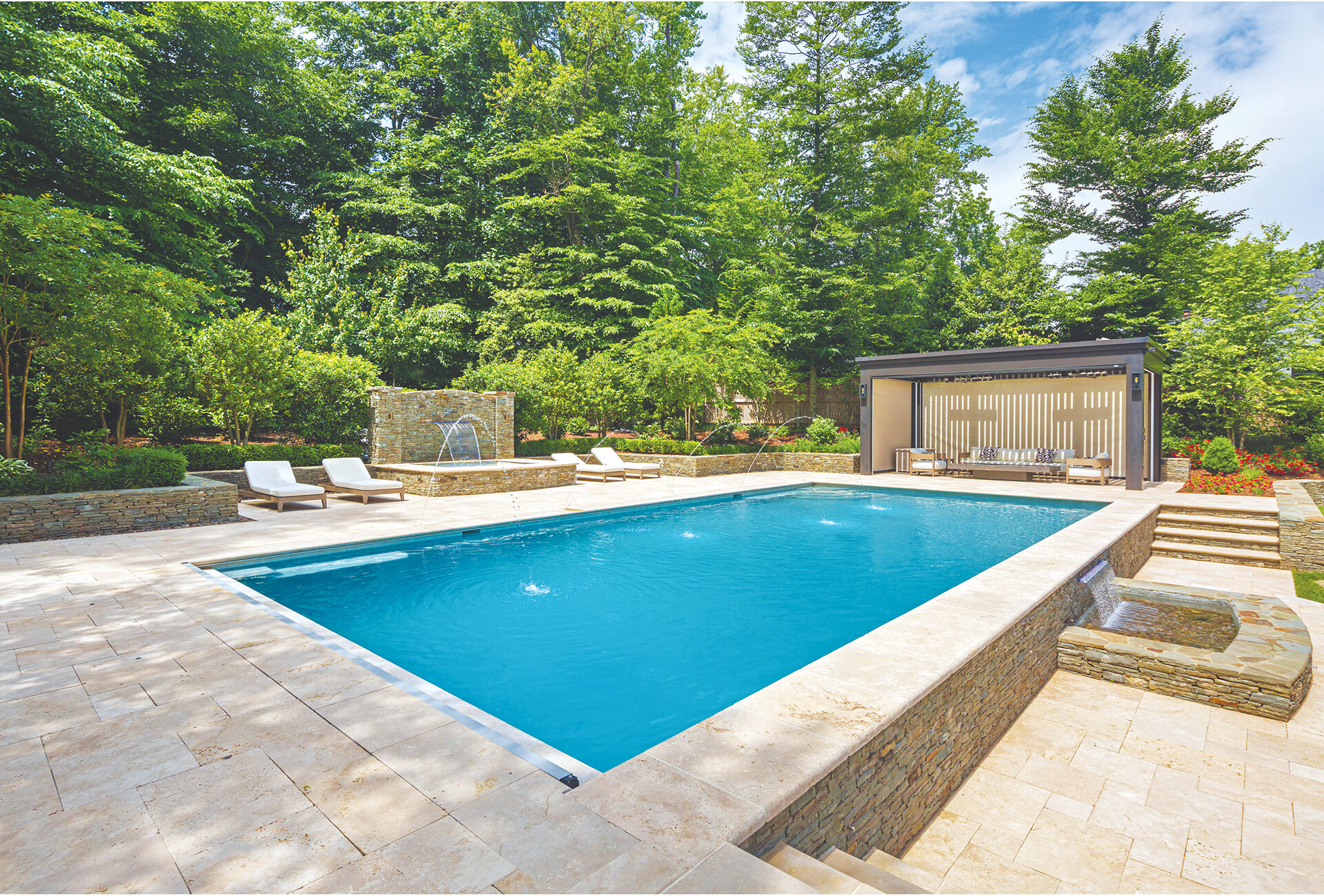 Rustic stone-walled swimming pool with travertine surround | Home and Design