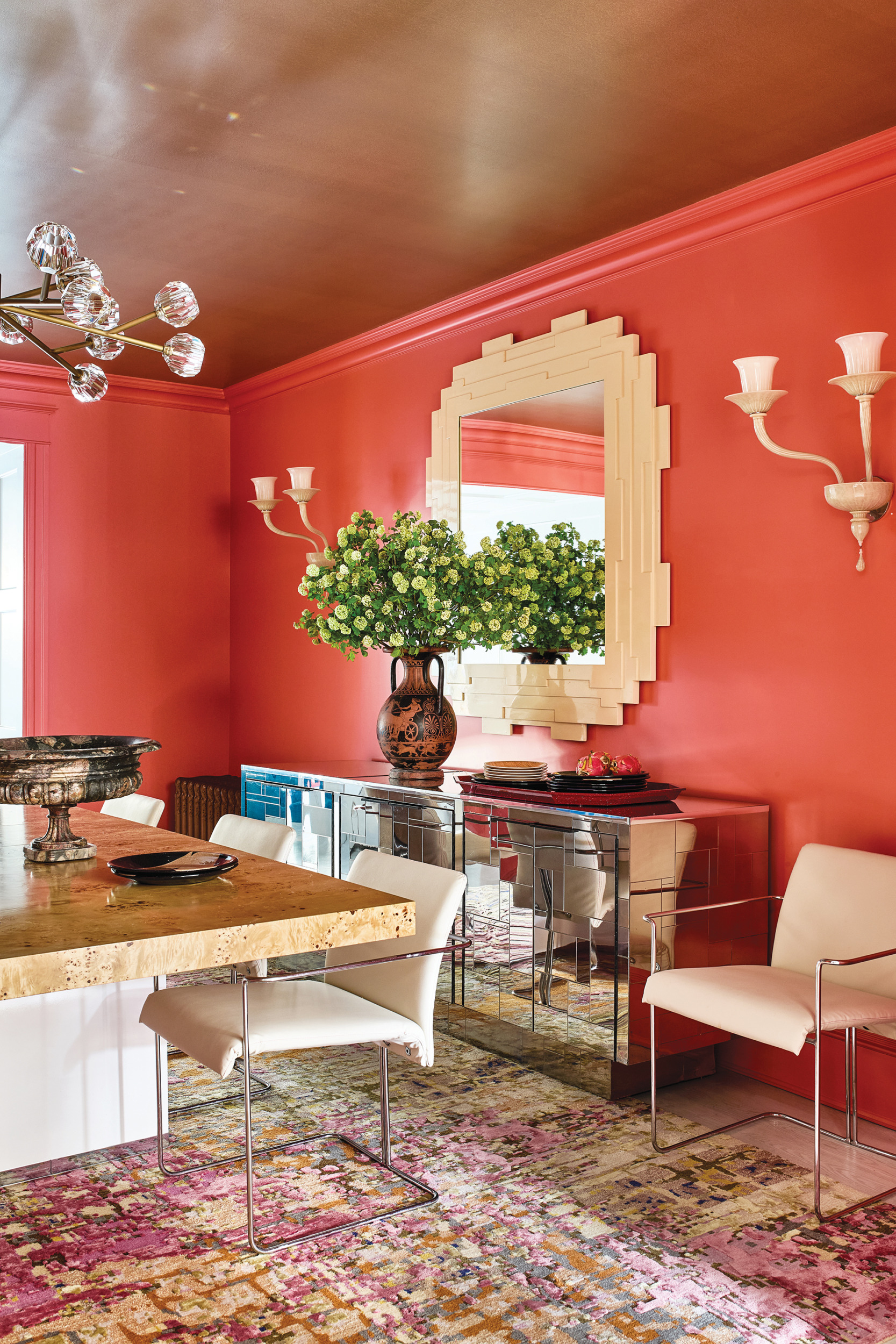 Dining room with Benjamin Moore’s Fan Coral walls, Paul Evans table, and chrome sideboard | Home and Design Magazine