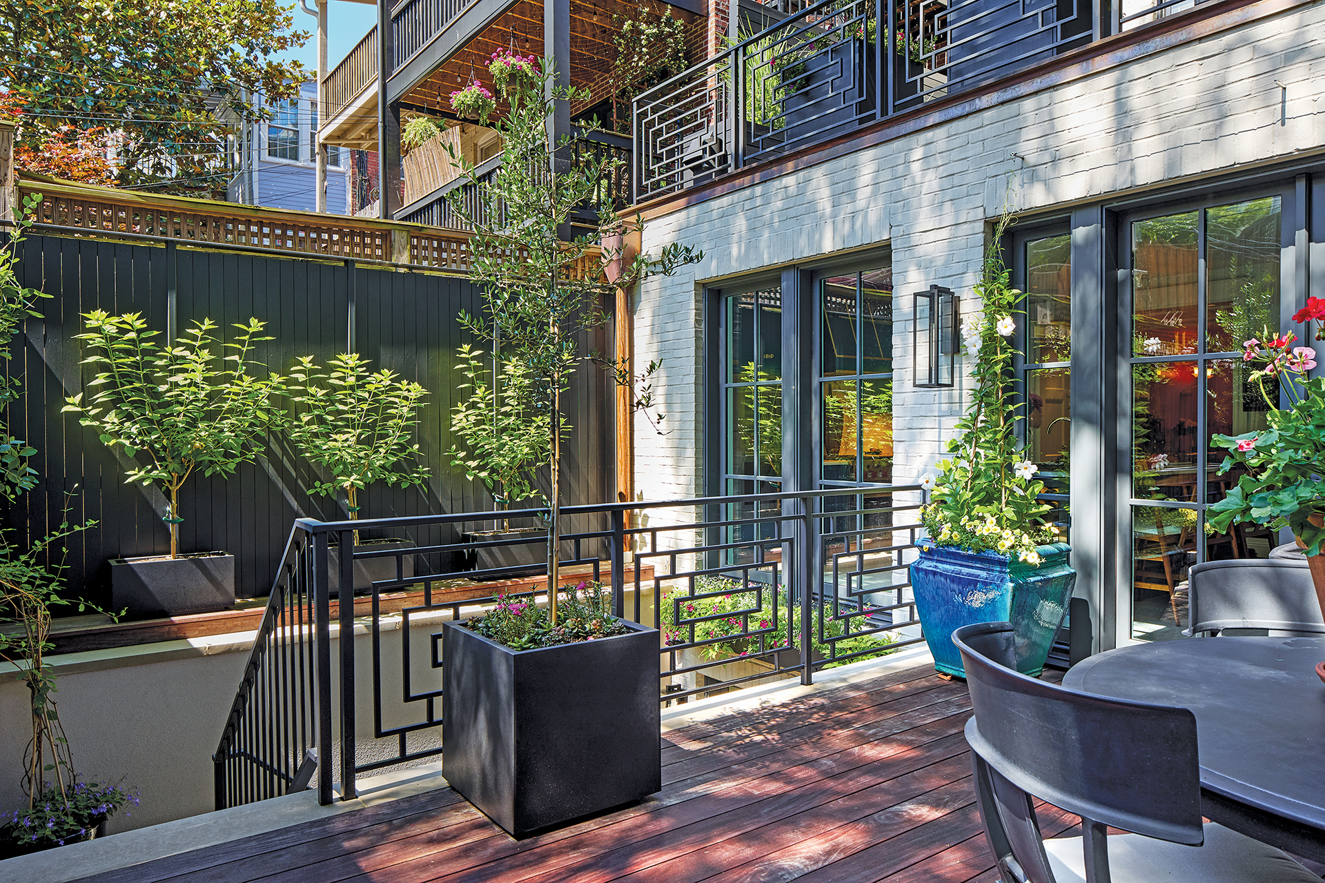 Custom-designed rail enclosing al fresco gathering spots and stairs to a walk-out basement apartment | Home and Design Magazine