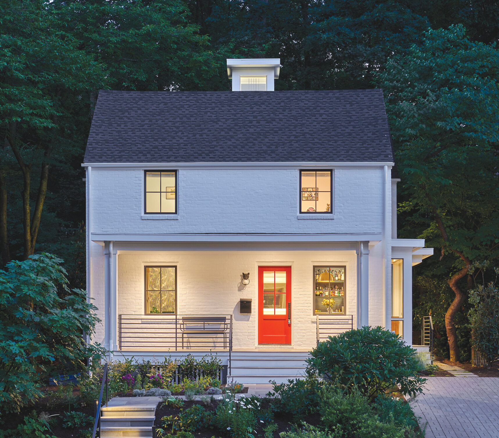 White brick colonial exterior with front porch and a red front door