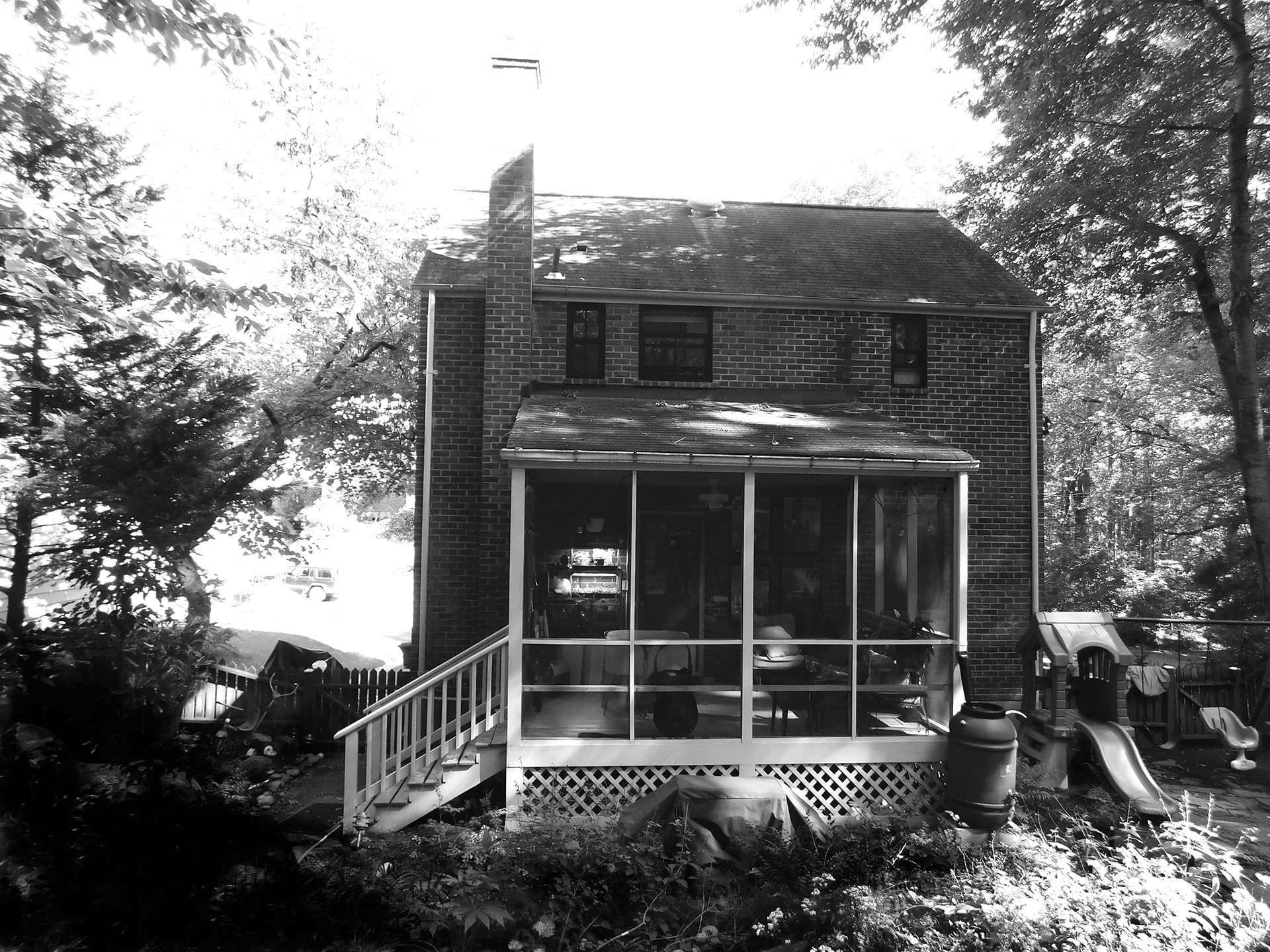 black and white before picture of a dated rear screened porch